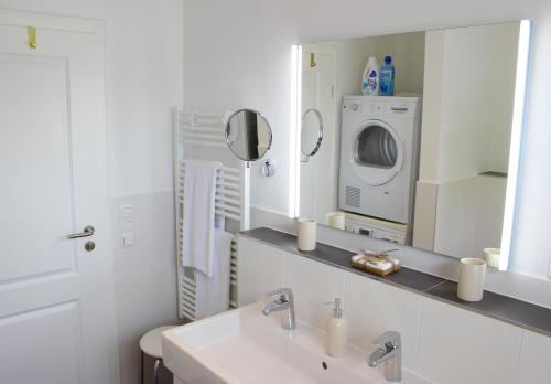 a bathroom with a sink and a washing machine at Penthouse Parkblick in Grömitz