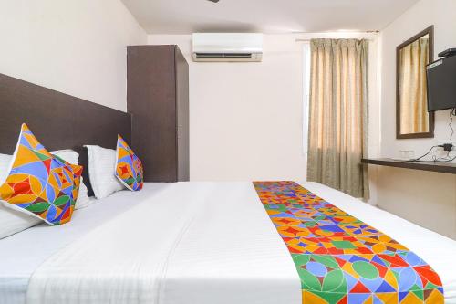 a hotel room with a bed with a colorful blanket at FabHotel Akshara Innotel in Visakhapatnam