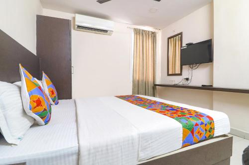 een slaapkamer met een bed en een televisie bij FabHotel Akshara Innotel in Visakhapatnam
