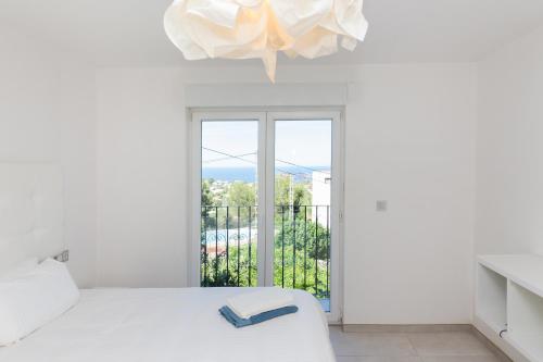 - une chambre blanche avec un lit et une fenêtre dans l'établissement Villa Siesta, à Dénia
