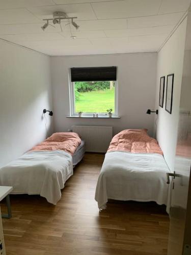 Duas camas num quarto com uma janela em Solhøj - a nice quite place just outside Billund em Billund