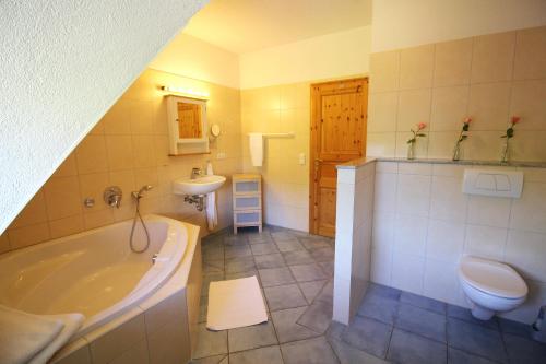 ein Badezimmer mit einer Badewanne, einem WC und einem Waschbecken in der Unterkunft Lieblingsplatz in Grömitz