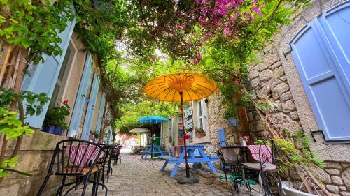 an umbrella sitting on a table in an alley at Maison d'Azur Alaçatı in Alaçatı