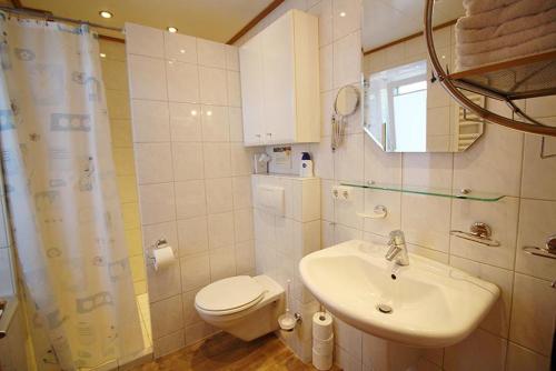 ein weißes Bad mit einem Waschbecken und einem WC in der Unterkunft Seestern in Bliesdorf