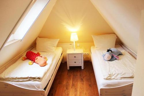 two beds with stuffed animals on them in a attic at Sperlingslust in Bliesdorf