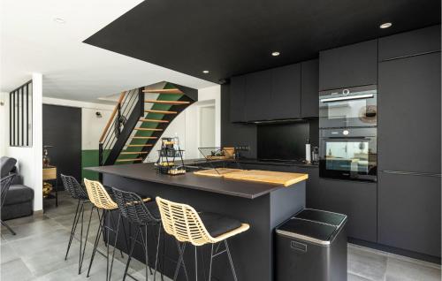une cuisine avec des placards noirs et un bar avec des tabourets dans l'établissement Home With Private Pool, à Saint-Jean-de-Monts