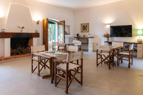 a dining room with a table and chairs and a fireplace at Pozzo Traverso Casale in Leporano Marina