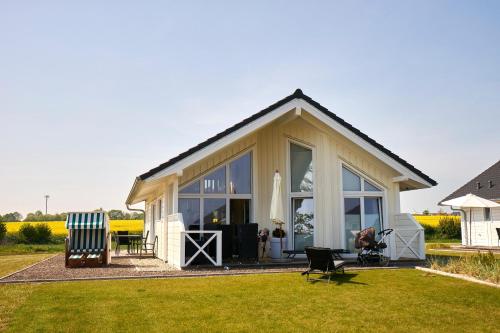 a house with large windows and a lawn at Luxuswellnesshaus Seepferdchen in Bliesdorf