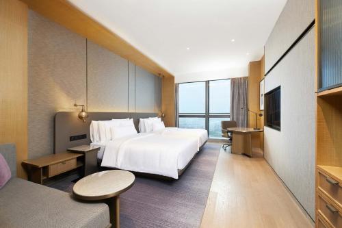 a hotel room with a large bed and a tv at The Westin Zhongshan Guzhen in Zhongshan