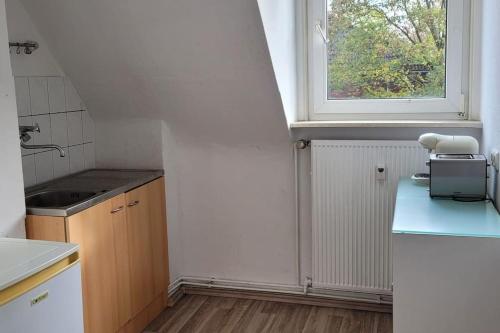 una pequeña cocina con fregadero y ventana en Schöne Wohnung im Stadtzentrum Herne, en Herne