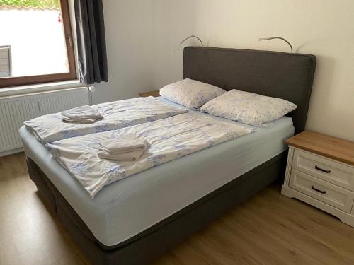 a bed with white sheets and pillows on it at Treibholz in Wustrow