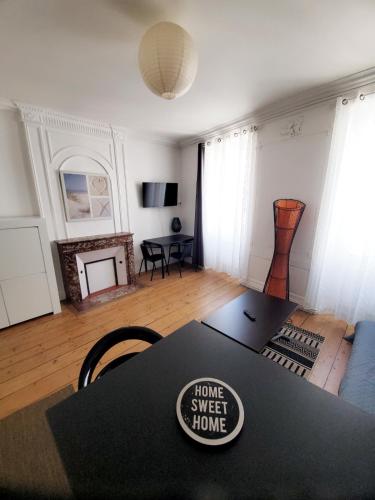 un salon avec une table avec un panneau « home sweet home » dessus dans l'établissement Le Perrot - 38m2 - 1 chambre, à La Rochelle