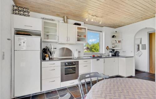a kitchen with white cabinets and a refrigerator at 4 Bedroom Nice Home In Assens in Assens