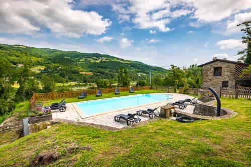 una piscina all'aperto con sedie e una casa di Agriturismo Il Salice a Tizzano Val Parma