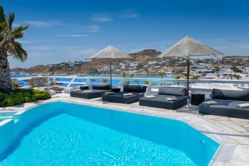 uma piscina com cadeiras e guarda-sóis num resort em Deliades Hotel em Ornos