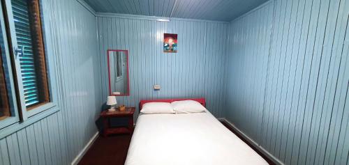 Habitación azul pequeña con cama y ventana en Hotel Golden Sea, en Vama Veche