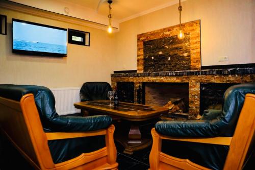 a bar with a table and chairs and a fireplace at Hotel Evergreen in Borjomi