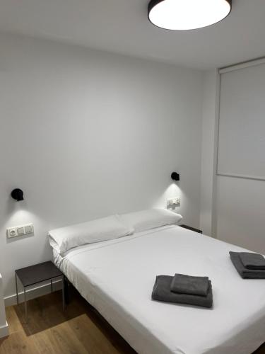 1 dormitorio con 1 cama blanca grande y toallas. en Anzaran, en Irún