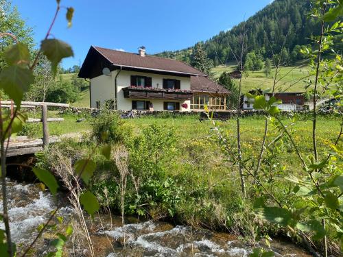 a house on a hill next to a river at Apartment Haus Christina in Großkirchheim