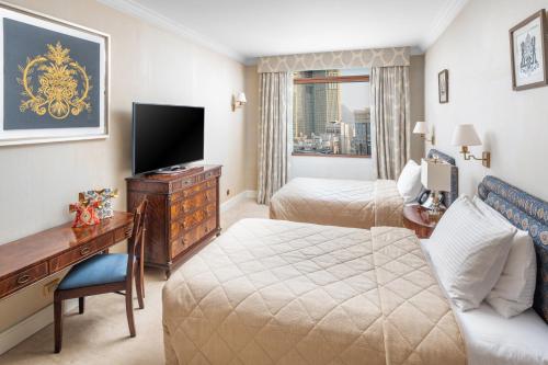 a hotel room with a bed and a desk and a television at Anjum Makkah Hotel in Makkah