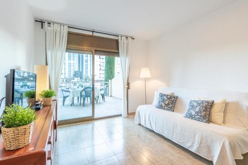 ein Wohnzimmer mit einem Bett und einer Glasschiebetür in der Unterkunft 161-Apartamento con vistas al mar a 100 m de la playa y en el centro de Empuriabrava-Empurialola in Empuriabrava