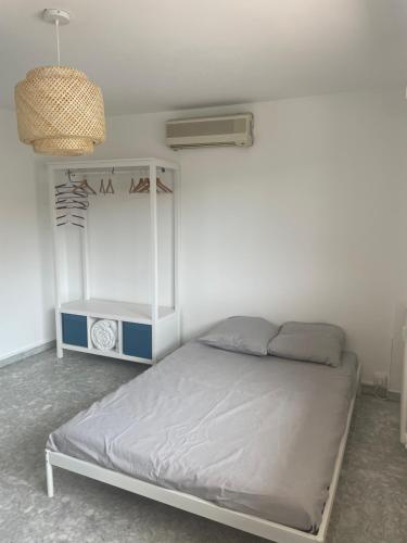 - une chambre dotée d'un lit avec un cadre blanc dans l'établissement APPARTEMENT VOLTAIRE, à Antibes