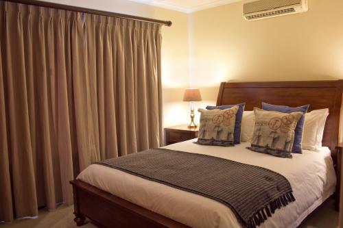 1 dormitorio con 1 cama y una ventana con cortinas en Bakgat Blyplek, en Beaufort West