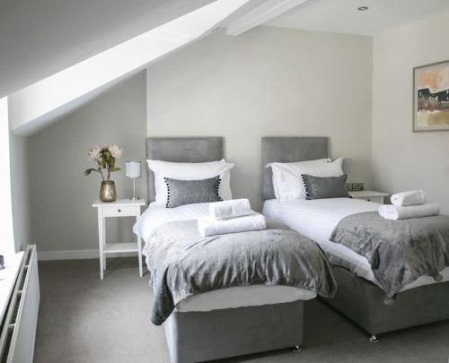 a bedroom with two beds and a table at St Magnus House, Fabulous Harrogate town house in Harrogate