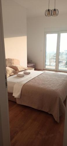 a bedroom with a large bed and a window at Apartments Radoman in Ulcinj