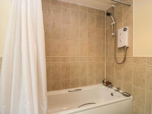 uma casa de banho com banheira e cortina de chuveiro em 16 Knightsridge House em Livingston