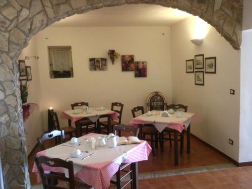 a dining room with tables with pink and white tablecloths at B&B Villa Makkalè in Vieste