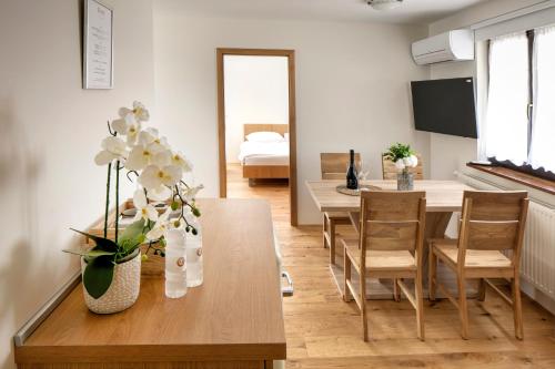 una sala de estar con una mesa de comedor con flores. en Guesthouse Turšič en Vrhnika