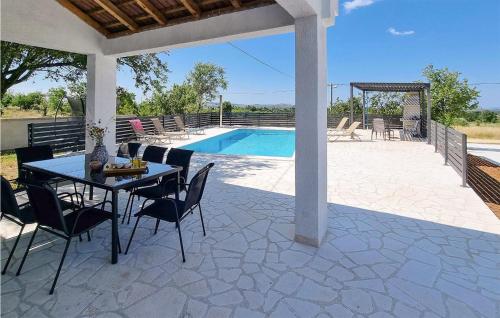 a patio with a table and chairs next to a pool at 4 Bedroom Lovely Home In Miranje Gornje in Miranje Gornje