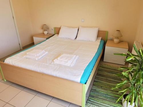 a large bed in a room with two night stands at orange in Ialyssos
