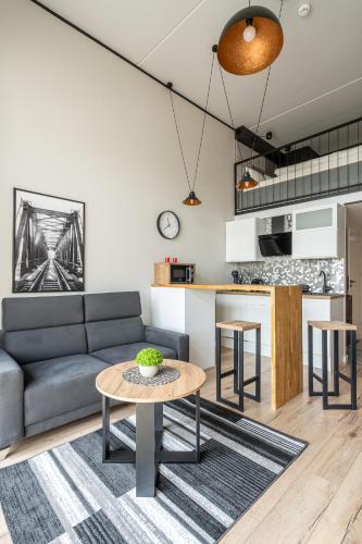 a living room with a couch and a table at RentPlanet - Apartamenty Zarembowicza in Wrocław