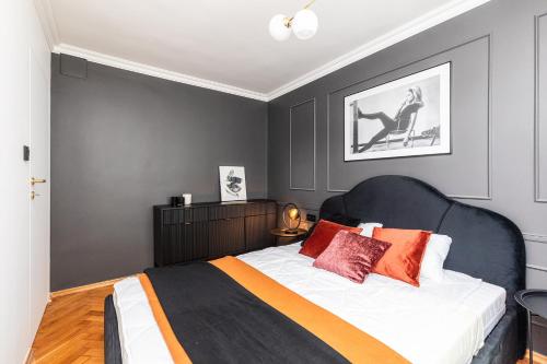 sypialnia z czarno-białym łóżkiem z pomarańczowymi poduszkami w obiekcie SuperApart Tamka 17 w Warszawie