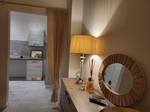 Zimmer mit einem Spiegel und einer Lampe auf einem Tisch in der Unterkunft San Siro Suite fiera in Mailand