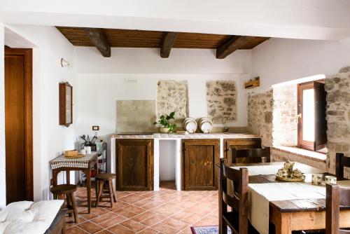 a kitchen with wooden cabinets and a table at LaVistaDeiSogni La Perla in SantʼIona