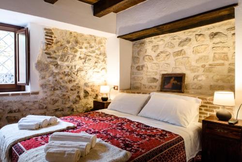 1 dormitorio con 1 cama grande y pared de piedra en LaVistaDeiSogni La Perla en SantʼIona