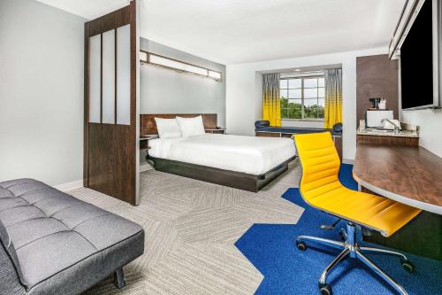 une chambre d'hôtel avec un lit et une chaise jaune dans l'établissement Microtel Inn & Suites by Wyndham Austin Airport, à Austin
