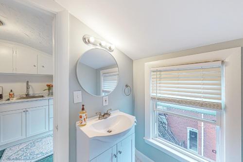 een badkamer met een wastafel, een spiegel en een raam bij Cumberland Casa - B in Portland