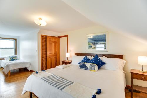 um quarto com uma cama grande e almofadas azuis e brancas em Waterfront Massachusetts Vacation Rental with Deck em Little Compton