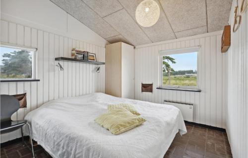 um quarto com uma cama branca e 2 janelas em Lovely Home In Ringkbing With Wifi em Klegod
