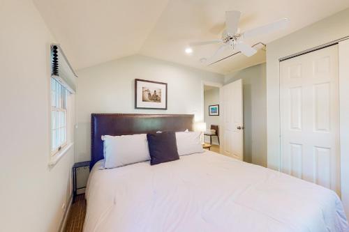 a bedroom with a white bed with a ceiling fan at Town of Rehoboth Beach 44 Henlopen Ave in Rehoboth Beach