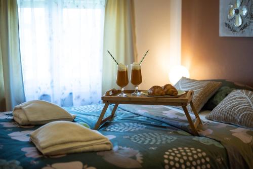 a bed with a tray of food and two glasses of juice at Apartmani Plavi val in Vodnjan