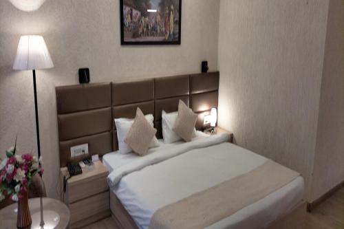 een hotelkamer met een bed en een lamp bij Fun N City Water Park , Adventure & Resort , Patna in Nadwān