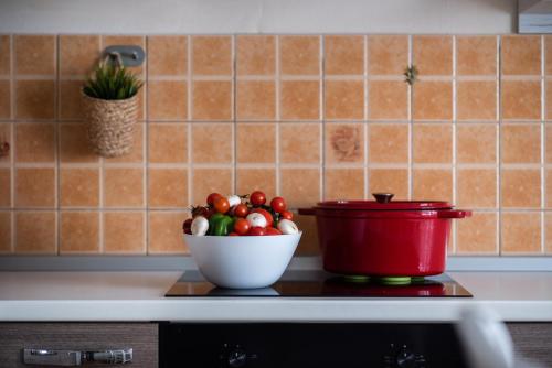 a bowl of tomatoes and a pot on a kitchen counter at Apartmani Plavi val in Vodnjan