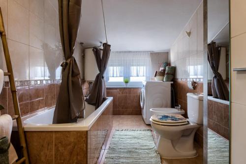 a bathroom with a tub and a toilet and a sink at Apartmani Plavi val in Vodnjan
