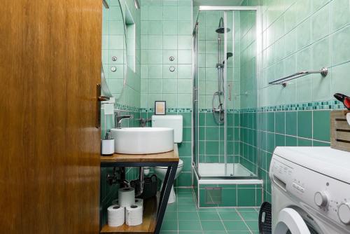baño de azulejos verdes con lavabo y ducha en Apartment Planikovica en Trogir