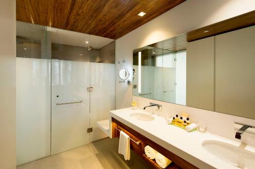 a bathroom with a sink and a shower and a mirror at Grand Hyatt Playa del Carmen Resort in Playa del Carmen